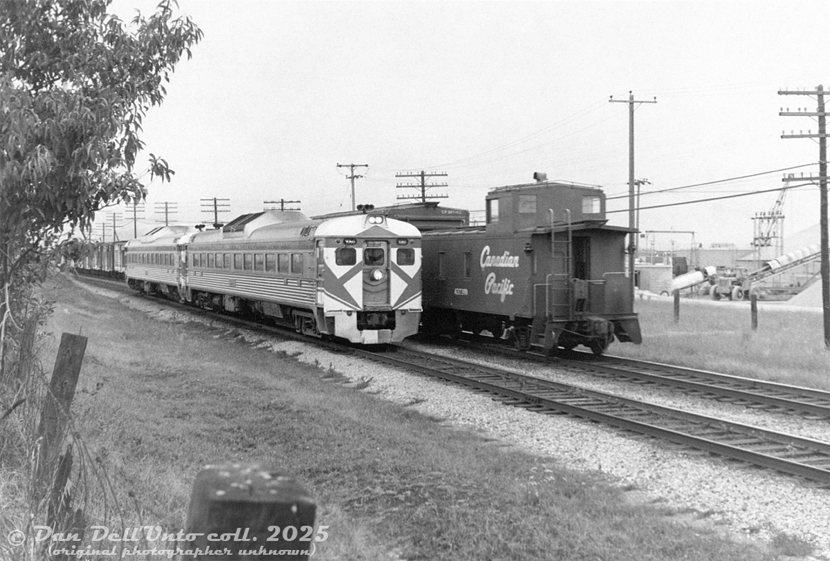 Having come up the Don Branch from Toronto Union Station and taking a right onto the Belleville Sub a Leaside, a pair of CP RDC-1's lead by 9060 head eastbound at Mile 200 between Warden and Birchmount Avenues, approaching the Highway 401 underpass. They're passing a westbound freight that appears to have a good amount of stock cars on the tail end, with CP steel offset-cupola caboose 437399 bringing up the markers. On the right is Canron Ltd's pipe manufacturing facility in Scarborough (served by rail siding), that became the site of a Simpsons-Sears warehouse in the early 1970's.

Original photographer unknown (possibly a Bill Grandin photo), Dan Dell'Unto print collection.