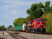 Fresh CP 7524 leads CPKC 2132 through Dorion, with KCMS 4652 trailing and KCS 4027 mid-train. At left is a small yard where commuter trains layed over for decades until a larger facility was built nearby a couple of decades back.