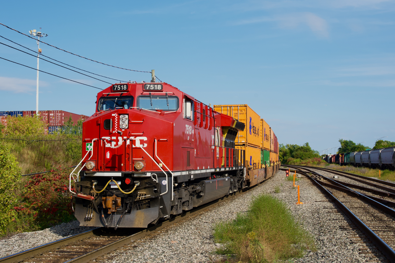 CPKC 119 is backing up towards Lachine IMS Yard as CN 368 passes at right. Fresh CP 7518 is head end power.