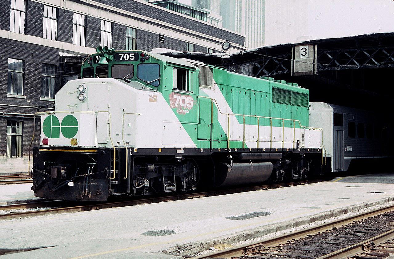 On a hot hazy summer day in August of 1983, a westbound GO Transit commuter train is seen at the west end of Toronto Union Station on track 3.