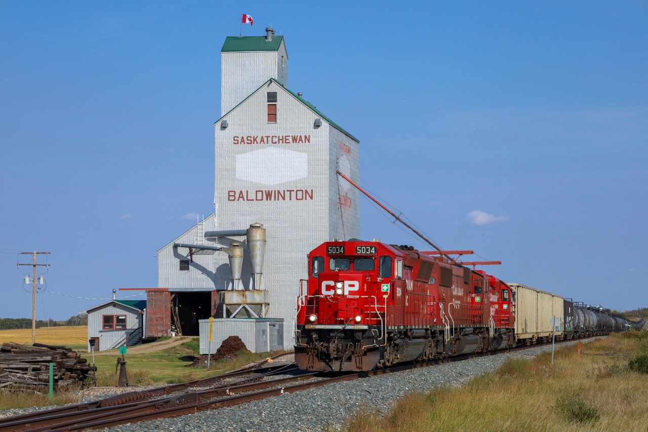 The Wilkie to Lloydminster local makes it way past the elevator at Baldwinton with CP 5034, CP 6258 and CP 3061 and 72 cars.