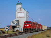 The Wilkie to Lloydminster local makes it way past the elevator at Baldwinton with CP 5034, CP 6258 and CP 3061 and 72 cars. 