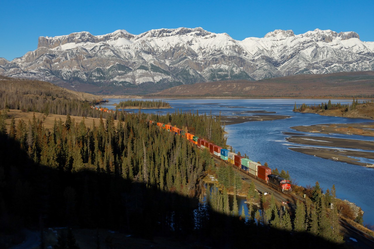 CN X 19991 08 races along the Athabasca River, as another beautiful day in Jasper National Park draws to a close. 

X 19991 08: CN 3815, CN 3881 – DP 1x1x0 – 166 cars