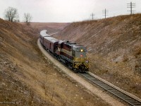Windsor - Toronto train 38 descends the grade through Barrie's Cut between Galt and Orr's Lake.  Soon after, an eastbound freight <a href=https://www.railpictures.ca/?attachment_id=54783>led by a leased Lake Superior & Ishpeming RSD12</a> will follow eastbound.<br><br><i>Scan and editing by Jacob Patterson.</i>