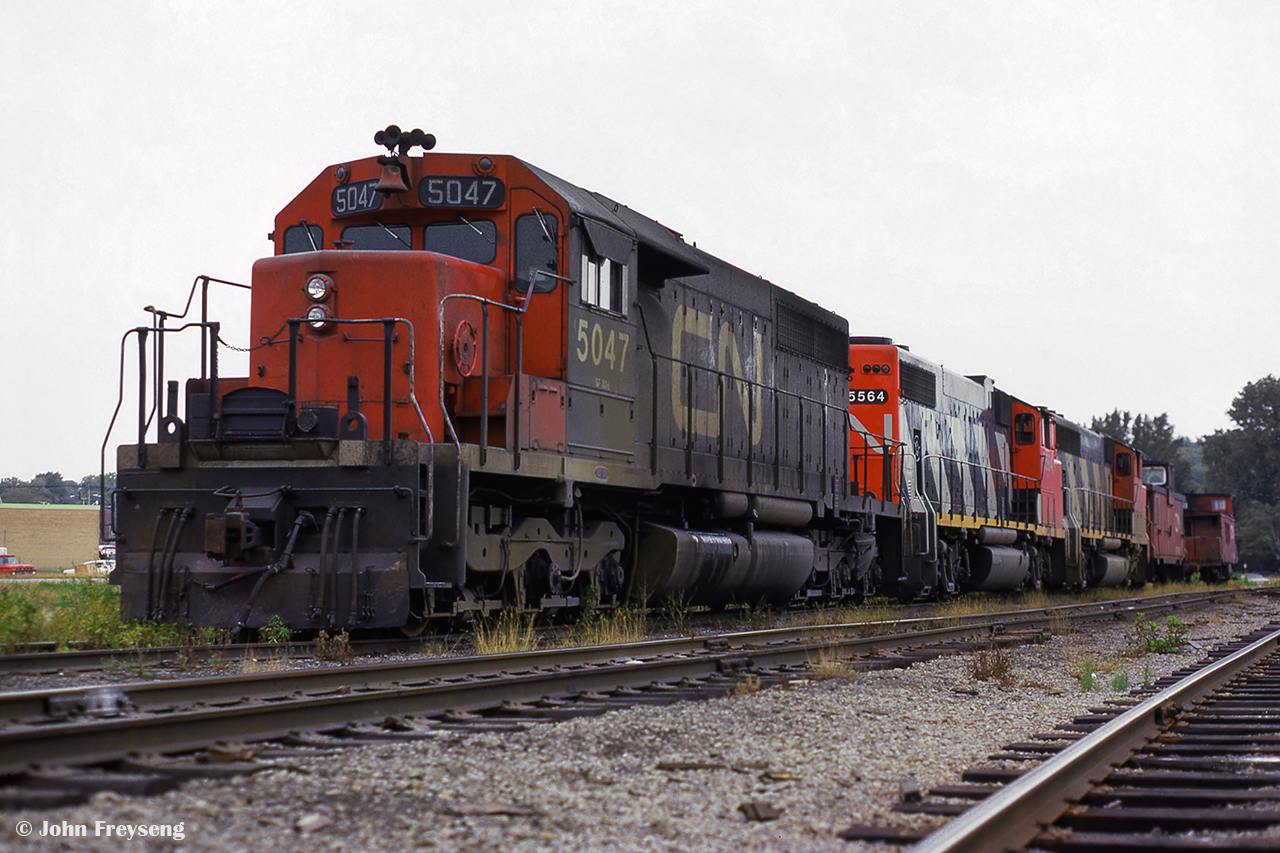 Power for the grain train out of Midland sits tied down in the yard waiting for its next trip south to Toronto.  Once grain traffic is lifted from the large elevators in town,the consist will be on the move to lift stone traffic from the Uhtoff Quarries, before heading for the Newmarket Sub at Midland Jct. in Orillia.

Scan and editing by Jacob Patterson.