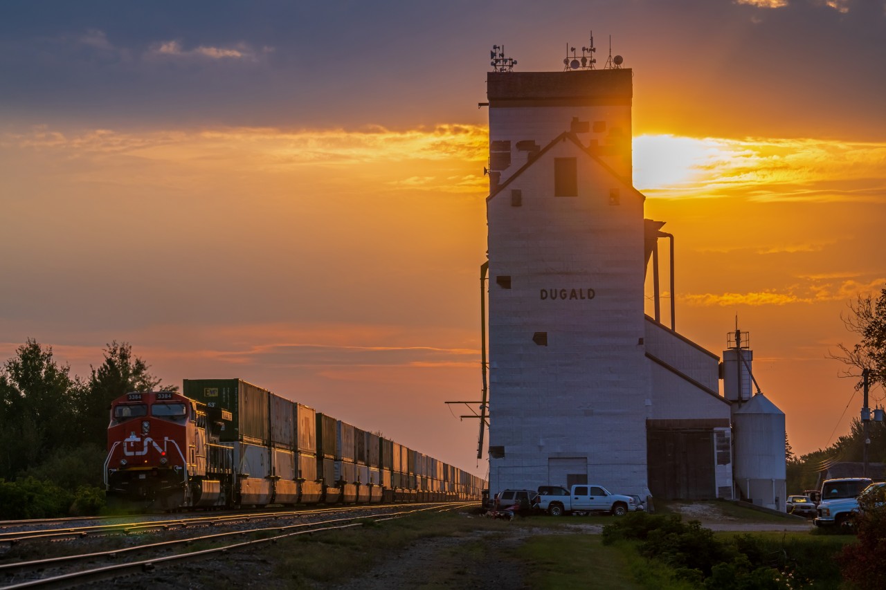 The trail end of a CN train heading East through Dugald Manitoba right after the summer sunrise.