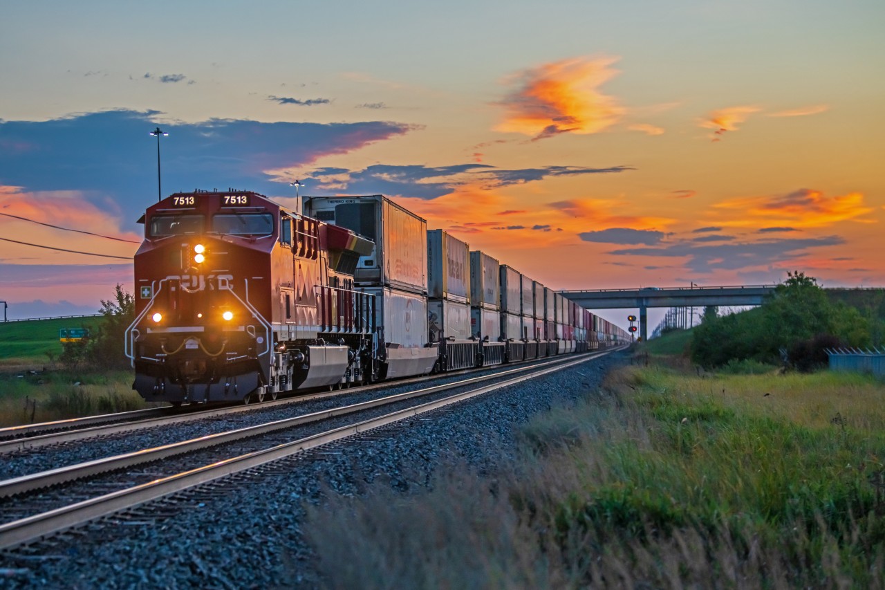 A freshly painted CPKC 7513 lead a long intermodel train into Winnipeg during a fall sunrise.