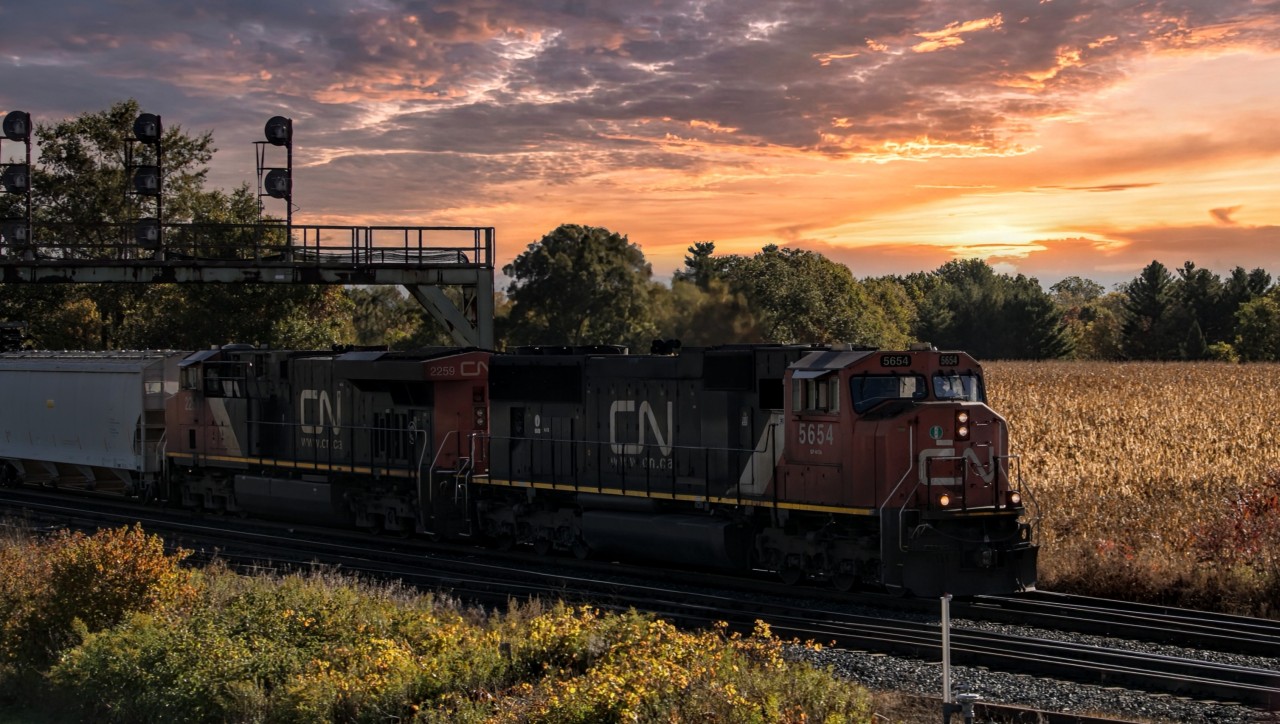 An early CN A425 crawls past the Paris West countryside and under the old signal tower at the beginning of the yard. An un-rebuilt CN SD70i is in the lead, which is also a treat. The sun also put on a show for the shot.