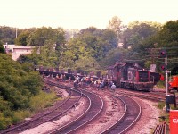 I can't help it, but when I look over this photo, an old time song which begins with "Hail, hail, the Gangs all Here" goes through my head.  There must be 30 bodies out there busy at trackwork right at the junction. It is a wonder they do not trip over each other. How times have changed. CN 1256 and 1318 power the passing train.