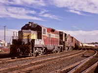 When the Fairbanks-Morse units on Canadian Pacific were approaching their end of service, one assignment remained strongly served by a few H24-66 Trainmasters — they were ideal for power, traction, and control for switching the hump yard at Alyth in Calgary, particularly as trailing units for modified GP9s.  Here, at the west end and approaching the 12th Street East interlocking tower (with the Blackfoot Trail overpass in the distance), CP 8635 and 8905 are slowly shoving a long string east over the hump on Wednesday 1974-10-02.

<p>Ten years later, CP 8635, by then further upgraded and modified for non-hump duties and renumbered 1580, became one of the first assigned GP9 yard units at the Coquitlam Locomotive Facility in Port Coquitlam and part of my work world as an electrician.  It was among the last GP9s to survive in yard service there, through to the end of 2013.  Note its short hood is NOT a chopped GP9 hood, which would have a central vertical flat area on the nose, but is more like a GP35 short nose.  Two other Alyth hump units, 8633 and 8634 (which became 1579 and 1576) were similarly equipped.