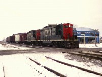 Typical blah winters-type day; grey terrain and grey skies and I am down at Jordan Rd crossing to see a local heading back to Niagara Falls (I presume) with an odd assortment of cars. I think this train had been working down at Winona, where the small yard there had a collection of rolling stock similar to what is on this train. CN GP9s are the power; 4595 and 4598. On the right is the old Vineland Growers Co-op building; current day this 100 year old business has a new sprawling building complex close by.