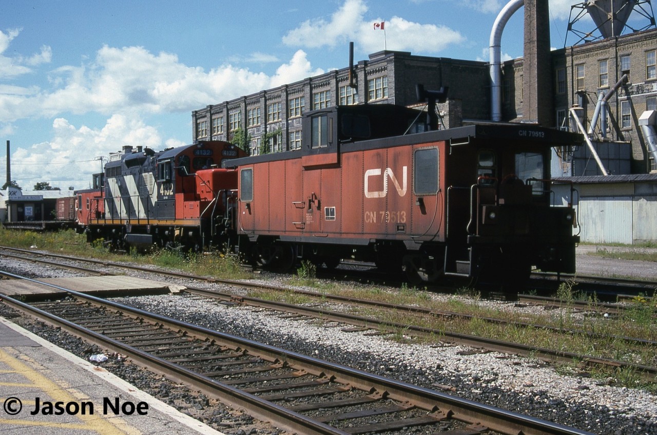 CN GP9RM 4132 and caboose 79513 are pictured awaiting their next assignment at Kitchener, Ontario across from the VIA Rail station and CN office. It likely would be that day’s 15:30 Job and a trip to the Budd Plant on the Huron Park Spur.