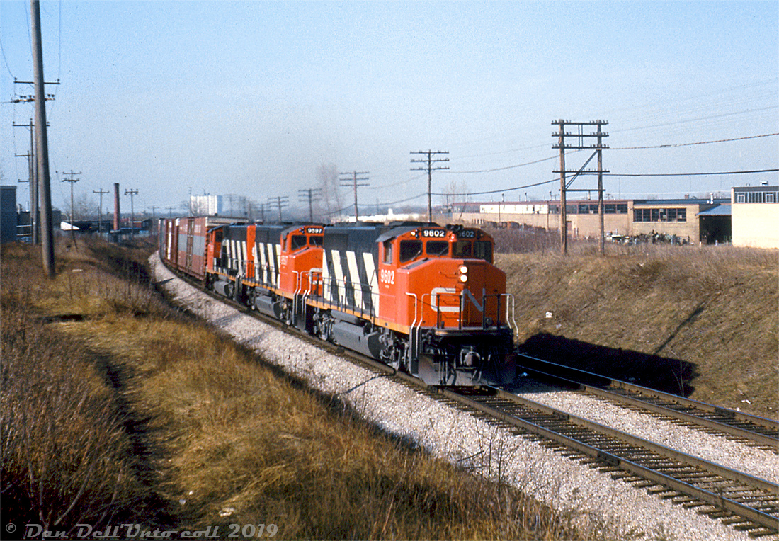 Matching zebra-striped CN GP40-2LW's 9602, 9597 and 9593 head up an eastbound auto parts train, rolling around the curve on the Kingston Sub at Birchmount Avenue near where the GECO Branch came off the mainline.

Mike Mastin photo, Dan Dell'Unto collection slide.