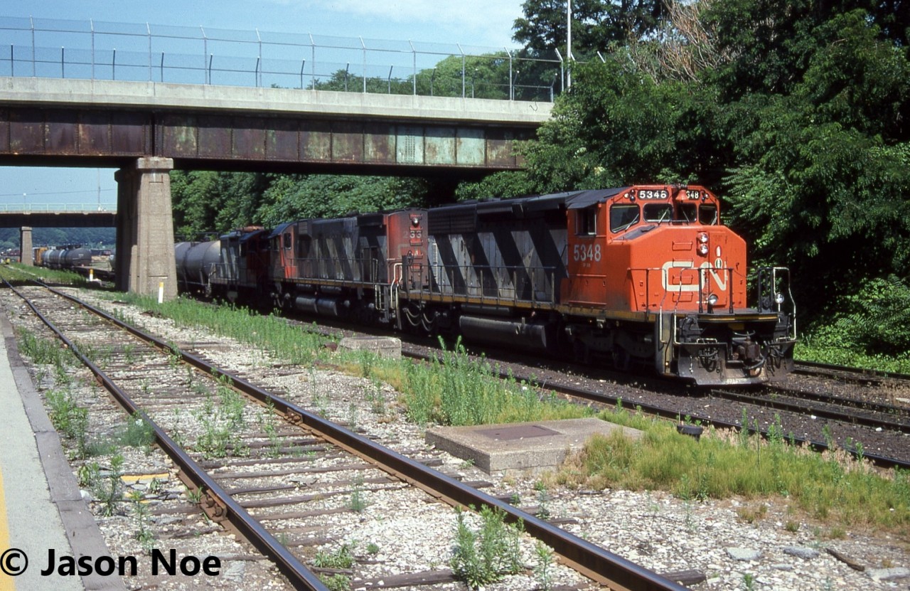 CN train 449 is photographed working Stuart Street Yard in Hamilton, Ontario. This was a regular MacMillan Yard to Niagara Falls train that normally worked Stuart Street yard in the morning. The consist included; SD40-2(W) 5348, M-636 2338 and GP9RM 4107.