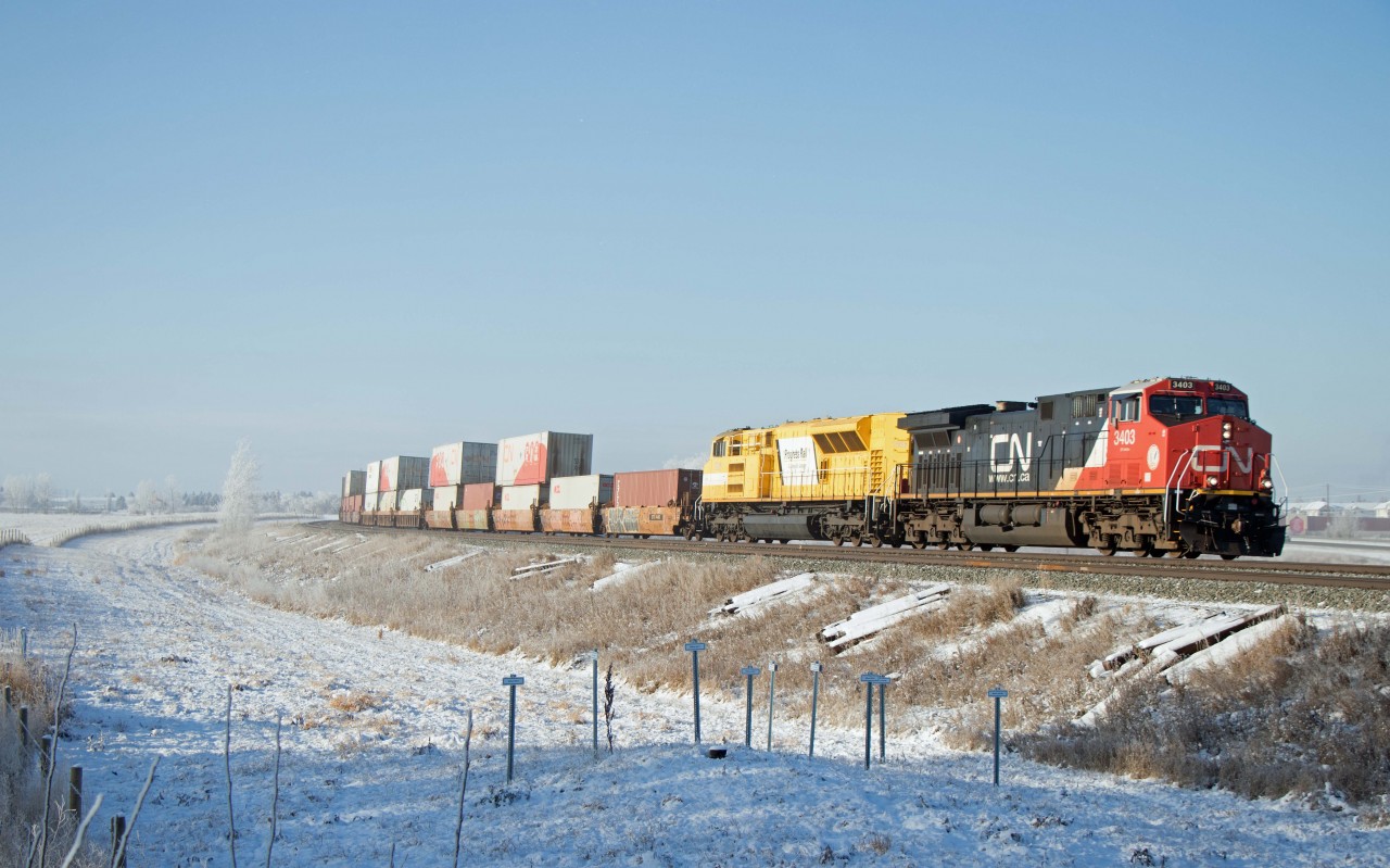 Daily intermodal train Z11251 (Vancouver Intermodal Terminal-Brampton Intermodal Terminal) rolls through the curve east of Spruce Grove just before noon on a chilly but bright Saturday morning. Up front are CN 3403 and EMDX 7206, assisted by tail end DPU CN 3041 (train number six in two hours on the busy Edson sub west of Edmonton).