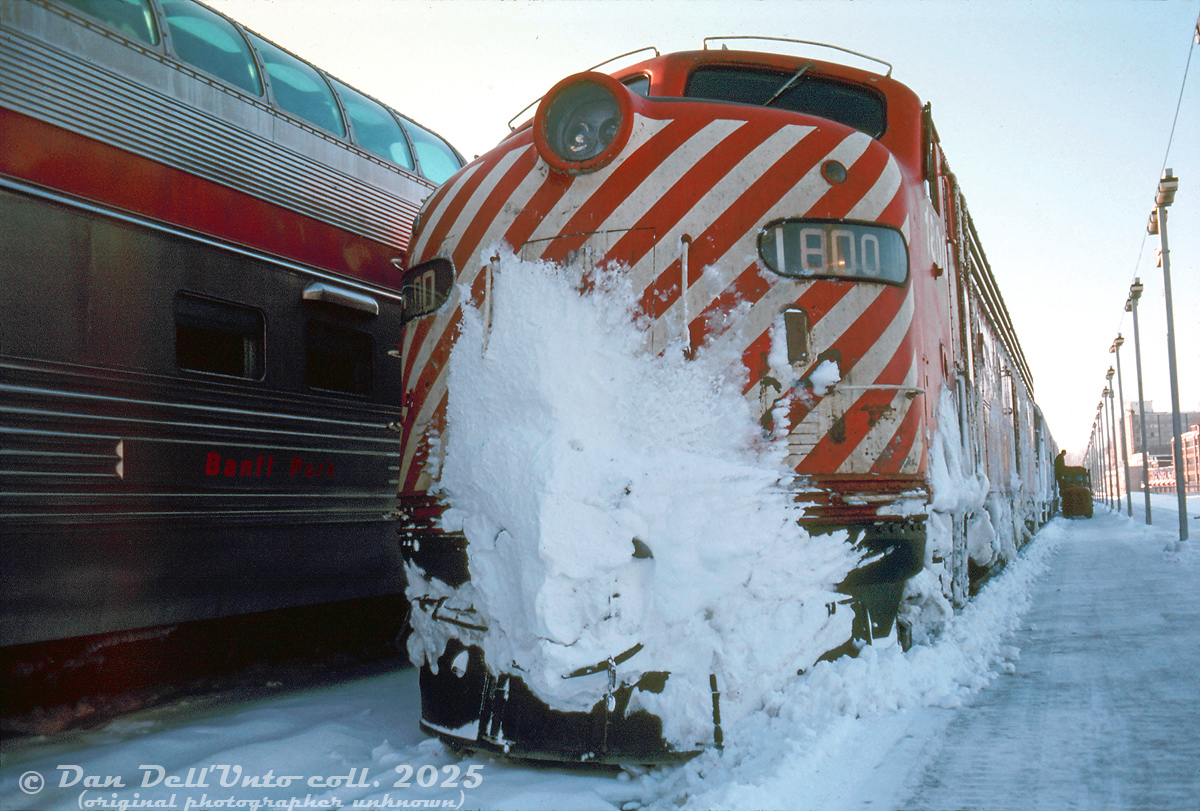 CP Rail E8 1800 looks like she's seen more than her fair share of snow drifts on the trip to Windsor Station, seen on the head end of recently arrived train #41, The Atlantic Limited. On the next track over, Banff Park trails on the tail end of the next train #1 (The Canadian) due out of Montreal.

 Original photographer unknown, Dan Dell'Unto collection slide.