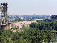 Delaware & Hudson PA1 19 leads seven passenger cars on Amtrak's "Adirondack" passenger train after its departure from Windsor Station in Montreal. It's seen crossing the St. Lawrence River on CP's Adirondack Sub coming off the double track bridge over the river itself, and about to cross the double lift bridge over the shipping canal into Kahnawake, Quebec, enroute to Albany NY in the US.<br><br>This photo was taken a year after the Adirondack began operating, initially using D&H equipment. Amtrak equipment would later replace the D&H's aging PA's and passenger cars in March 1977. D&H's four PA's (16-19) would then be briefly leased out for Boston commuter service, and later sold to FNM in Mexico. <br><br> <i>Max S. Robin photo, Dan Dell'Unto collection slide.</i>