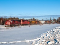 Accelerating down the grade leaving the town of Ignace the crew of this prairie bound grain empties doesn't need much power for their pair of "barns" (CP 9022 and CP 9003) to get the train up to the track speed of 50 MPH. Looked like it was a typical frigid winter evening in northwestern Ontario, complete with a set of moose tracks through the snow in the foreground.
