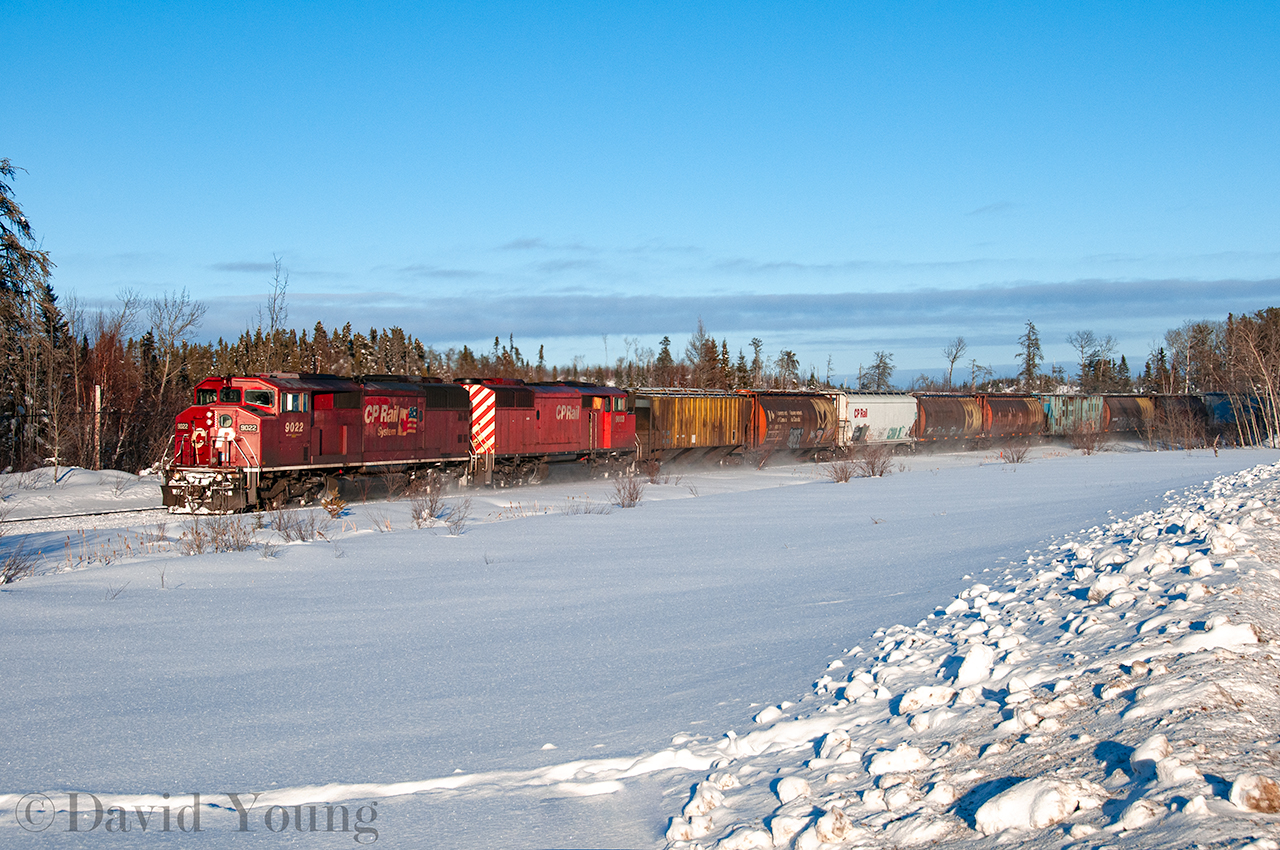Accelerating down the grade leaving the town of Ignace the crew of this prairie bound grain empties doesn't need much power for their pair of "barns" (CP 9022 and CP 9003) to get the train up to the track speed of 50 MPH. Looked like it was a typical frigid winter evening in northwestern Ontario, complete with a set of moose tracks through the snow in the foreground.