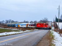 <b>South Pulls North.</b> The first snow is over and now it's a downpour- just an absolutely miserable day. Ontario Southland's St Thomas job is half way home, crossing Crampton Rd outside Mossley with a pair of unusual bedfellows in the form of a former passenger coach and baggage car from the defunct York-Durham Heritage Railway. Disappointing what happened in Uxbridge, but these two pieces have been spared from the scrappers torch and will be painted at OSR's shop in Salford for the VIA Rail Historical Society. Once completed they will head to Mimico to join the organizations other equipment including their FP9u 6539 (the former OSR unit which received the same treatment last year). Sort of interesting capturing a former Ontario Northland coach on the Ontario Southland. Even more interesting having this equipment together as their own train as there was no other traffic ex St Thomas to bring back towards CPKC.