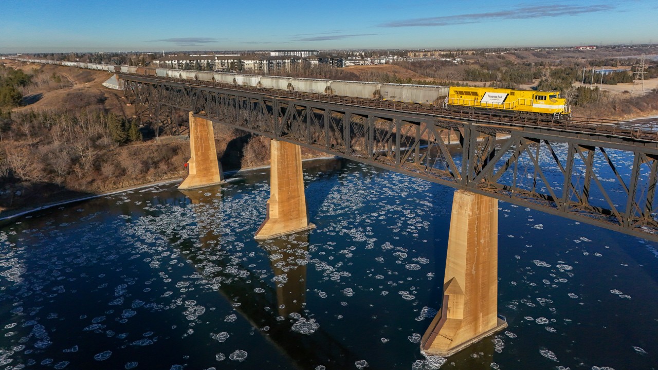 The North Saskatchewan River is starting to freeze over, as EMDX 7206 shoves a 100 car train into Edmonton from the Crush plant at Dufualt, Saskatchewan.