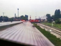 Lots of activity at West Toronto as the Canadian takes on passengers and waits to cross onto the Mactier Sub.  An eastbound freight behind an SD40-2 and a big MLW pound across the diamonds, while an MLW switcher can be seen waiting to clear the Mactier Sub.  Also note two yellow switchers in Andrew Merrilees yard.

<br><br><i>Scan and editing by Jacob Patterson.</i>