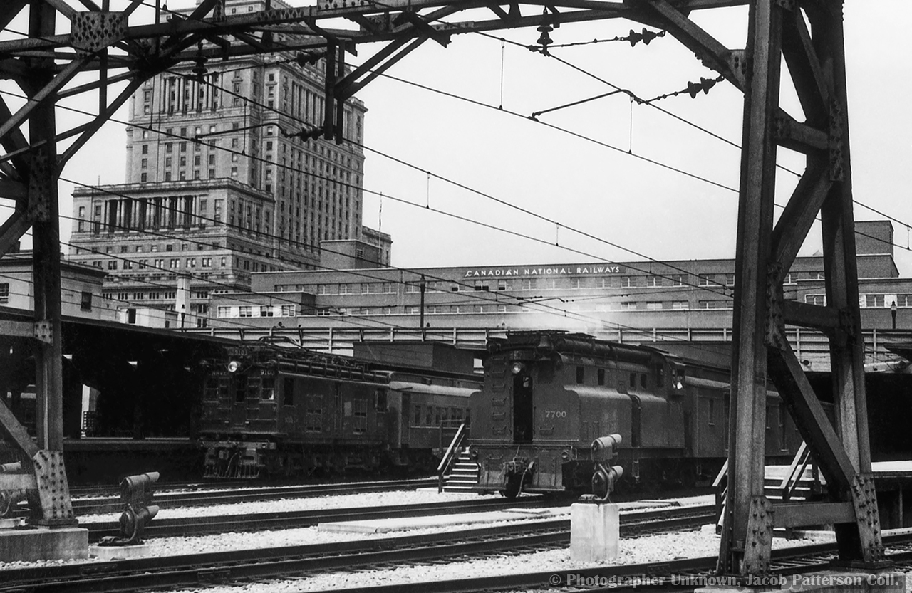 CNR boxcab electric 9103, originally Canadian Northern 603, sits at the head of a commuter consist at Montreal's Central Station while one of a kind "visibility cab" switcher CNR 7700 handles terminal switching duties.  Built in 1929 as the CNR's first diesel switcher locomotive, and powered with a 400hp Beardmore engine, CNR 7700 worked the Montreal area for a number of years, in addition to time at other terminals and on the Thousand Islands Railway.  Renumbered to 77 in 1950, the  unit would be donated to Exporail in 1968.  Towering over the scene is the Sun Life Building, built in three phases from 1914 through 1933.

Original Photographer Unknown, Jacob Patterson Collection Negative.