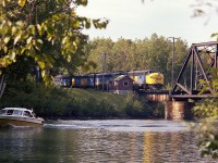 Nice warm early fall afternoon and the "Super C" is southbound over the Trent-Severn waterway by way of the historical CN swing bridge (or Drawbridge, in RR terms). The power is VIA 6521, 6623, 6533. This location is but a mile out of Washago. Back in the day, Washago was a great place to hang out as there were a good number of CN freights as well as the ONR Northlander. I am assuming the structure by the bridge is the bridge tender's quarters.