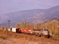Fortunate timing in my life with a driver’s licence and vehicle in 1973 allowed me to see the last full year of Fairbanks-Morse locomotive activity on CP, centred on Nelson.  On Friday 1974-10-11, a train returning from Midway to Nelson was a prime target, with a mixed consist of CP 4104 leading GM 8509 and FM 8555 and GM 8526, shown here leaving Kraft in forest fire haze and passing the mileboard to Robson West and milepost 28 to Nelson.