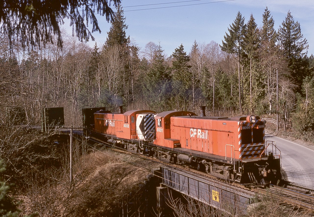 If ever there was a fortunate-timing shot, this one on Thursday 1975-03-06 qualifies, just seven days before the beginning of the shutdown of all CP Baldwin roadswitchers, completely unknown to me at the time of the photo.  A potential tree perch to catch northward freight No. 51 from Victoria to Nanaimo had been on my radar for some while, and with a pair of Baldwins, 8001 and 8002, and brilliant sunshine, this view of the overpass of Northgate Road at mileage 29.8 near Cobble Hill worked out, just enough of an angle that the short hood of the lead unit was not completely hidden behind the cab.

Note the feet-and-inches clearance sign on the bridge.