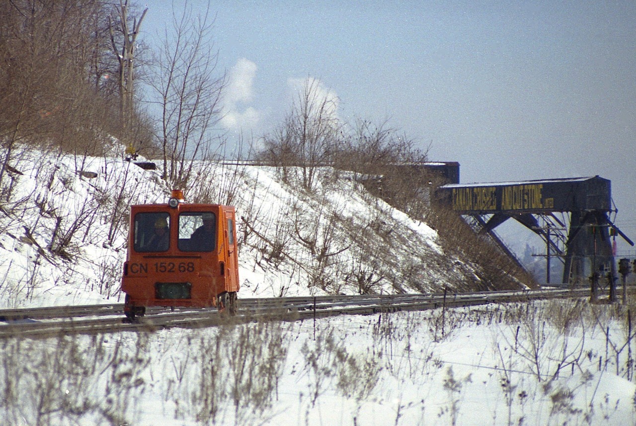 Something different you do not see any more......unless perhaps you are one of those aficionados that enjoys outings on your own personal machine.
Speeders were once common as track patrol vehicles, and I used to see this one regularly along the Dundas. I don't know where he set out from but assume he went as far as Bayview and then returned. Brantford? Anyway, here is CN 15268 rolling west past the old Canada Crushed Stone conveyor structure around mile 4.4 on the Dundas. The track remains, of course, but the rest of the scene is history.