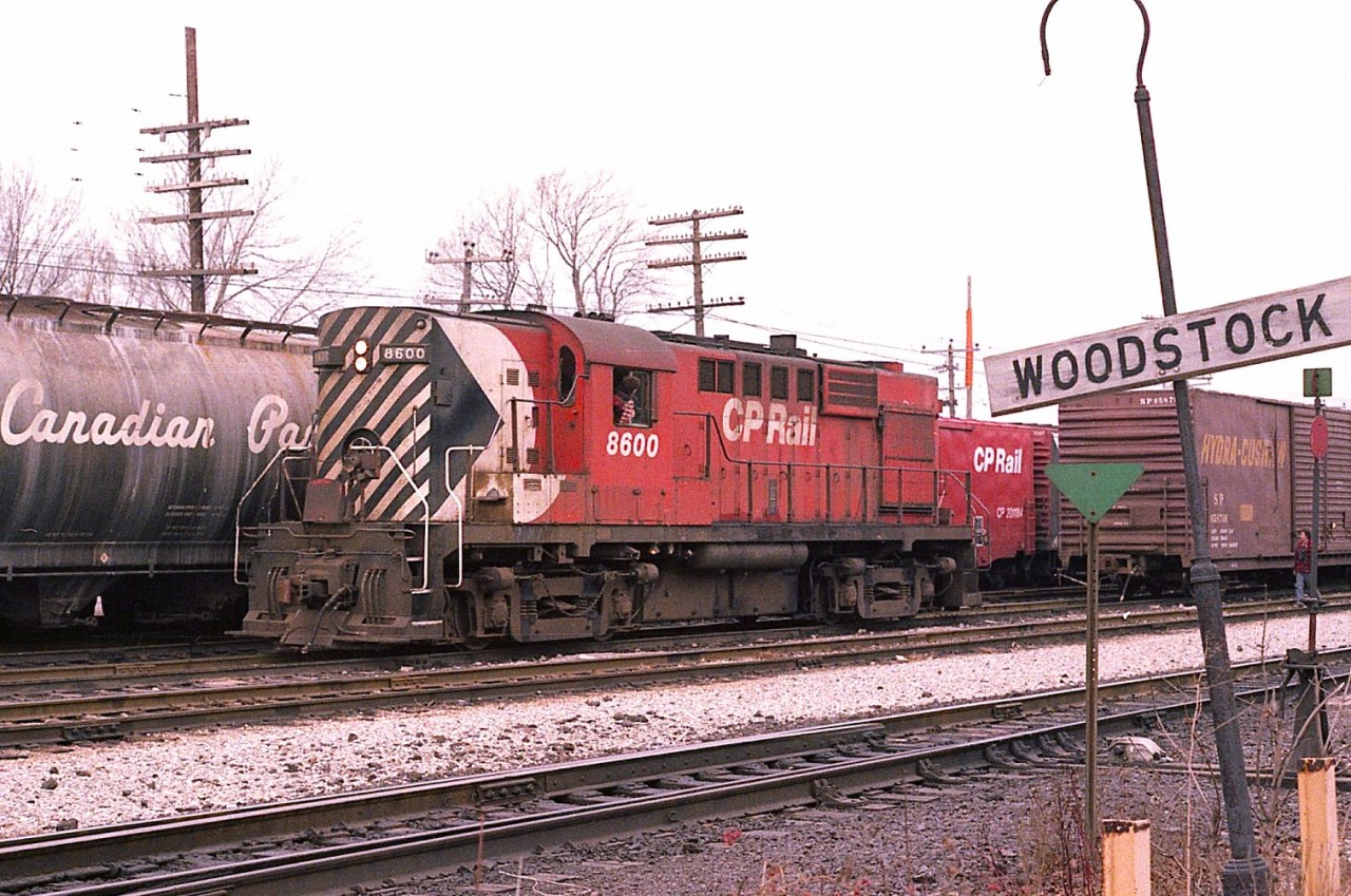 CP 8600, an MLW RS-10s, works a cut of cars in front of the Woodstock station. Unit was built 1956 and gone by 1984. (Nice wooden name sign!!  Where is it now?)