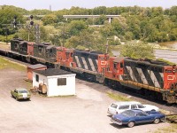 For me personally, this is a classic Bayview memory. A nice afternoon up on the hillside watching the Pulp train go by on its way Port Robinson and the setting out of many cars of logs for the Thorold Pulp and Paper company.
Yes, of course. All gone now as the GP9s have all been rebuilt, renumbered and or retired. And Thorold Paper has closed up shop.
Power this afternoon is CN 4565, 4495, 4527 and 4571. 
Don't know who owned that little Vega. My car is parked next to (the late) Bill McArthur's station wagon. I miss those days, and miss Bill a lot too.