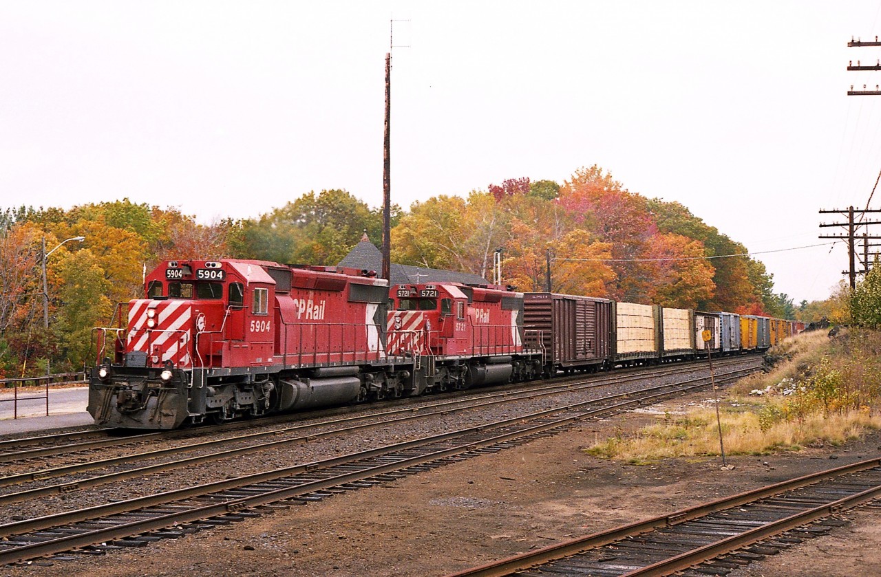 The fall colours are beginning to kick in around Parry Sound.  That's one of the reasons for the visit to this lively community of 6,000 people.  The main reason, of course, is to see trains.
I'm on the south side of the tracks by the entrance to the small Parry Sound CP yard and grabbing a pic of CP 5904, 5721 heading toward Toronto.
So much has changed. It is but a single track thru here now. The station, now repurposed, can be seen in the background.