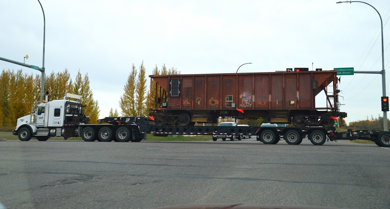As I put this to RP, I get to wondering if it qualifies as a railroad image. But, hey, it does have a hopper in it.
It flabbered by gaster to say the least when I was stopped for a light after coming out of a plaza on the west side of Lloydminster (the Alberta side) and this goes rolling thru. It is heading west on the Ray Nelson Drive, which is also 44th St or the Trans-Canada (take your pick) and I am on 75th Ave looking north. You can barely make out the signs in the photo. The cab appears to be Kenworth, Cypris Transport operated.
This was shot thru my front window. I had no time to exit the car.  Something not often seen.