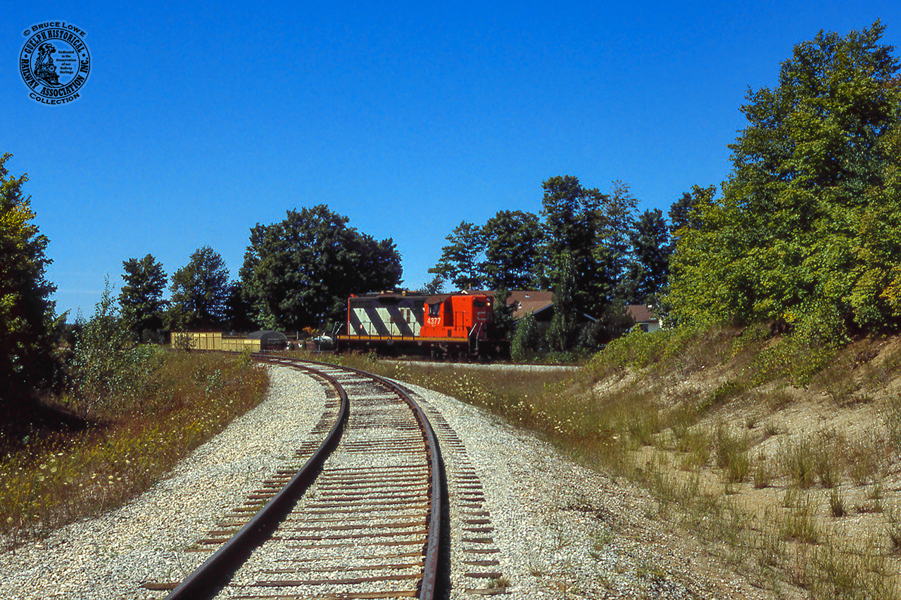 Quiet branchline railroading near Ontario's Saugeen Shores, CN 4377 backs around the wye at Port Elgin, taking the north leg over to the Southampton Spur.  They'll soon lift their train and depart for Stratford.

It would appear that the spur in the foreground, built in 1970 for the Bruce Nuclear Power Development plant at Douglas Point, was reassigned as the Southampton Sub main at some point.  Canadian Transportation Commission Order 35400, issued July 25, 1983, authorized the abandonment* of "b) the Southampton Spur, off mileage 48.19 of the Southampton Subdivision, from a point near Port Elgin (mileage 0.90) to Southampton (mileage 5.00), a distance of 4.10 miles."  This of course had been the mainline to Southampton.

*CTC Order 35400 authorized the abandonment of the following lines:

a) the Durham Spur, off mileage 1.3 of the Owen Sound Subdivision, from Whites Junction (mileage 0.00) to Durham (mileage 25.72), a distance of 25.72 miles;

b) the Southampton Spur, off mileage 48.19 of the Southampton Subdivision, from a point near Port Elgin (mileage 0.90) to Southampton (mileage 5.00), a distance of 4.10 miles;

c) the Kincardine Subdivision from a point near Listowel (mileage 1.41) to Kincardine (mileage 57.82),La distance of 56.41 miles; and

d) the Fergus Subdivision from a point near Fergus (mileage 47.00) to a point near Palmerston (mileage 72.00), a distance of 25.00 miles.