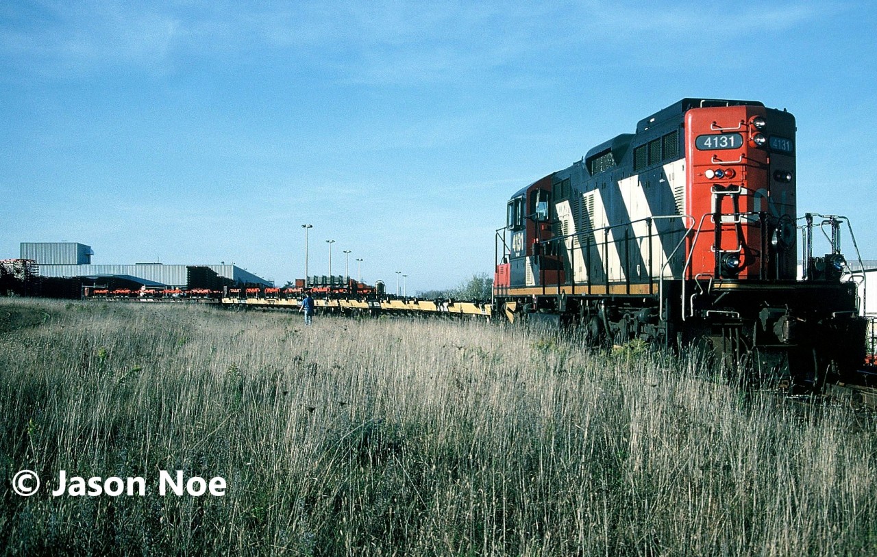 During a pleasant fall afternoon, the CN 15:30 Kitchener Job is busy switching the large Budd automotive frame plant in Kitchener, Ontario with GP9RM 4131. Every weekday afternoon, the job would traverse the Huron Park Spur to service the plant, lifting the loaded frame cars and setting-off the empty flatcars.
