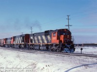 A cold, clear morning trackside yields an all-MLW lashup of CN C630M 2007, HR616 2112 and M420 2551 rolling an eastbound freight up the Halton Sub, curving north about to pass Walker's Line. The critter in the background is for the Canadian General Electric plant that was once here, that had its own siding.
<br><br>
<i>Bill McArthur photo, Dan Dell'Unto collection slide.</i>