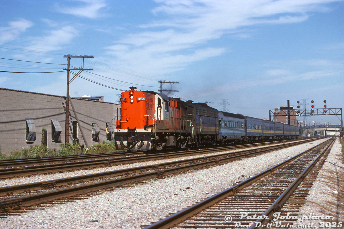 CN Tempo RS18 3153 leads VIA F9B 6633 westbound on the Oakville Sub on VIA train #83, heading through Mimico East leaving the QEW overpass, L.J. McGuinness distillery and Stelco Swansea plant in the distance. Today's consist of blue and yellow ex-CN passenger cars is led by one of the former Reading "Crusader" observation cars (300 or 302), that will likely take its turn on the tail end of the train on the trip back to Toronto.

Peter Jobe photo, Dan Dell'Unto collection slide.