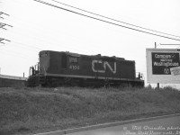 CN 4100, one of the lightweight freight/passenger service GP9's assigned to Spadina Roundhouse, works a local freight switching on the Newmarket Sub just south of St. Clair Avenue station  It's seen switching the lead on the east side along Caledonia Road leading to Darrigo Brothers, Caledonia Food Distributors and Meschino Banana Company.<br><br>The building and loading dock for Pietro Culotta is visible in the background, along with a PGE reefer spotted at one of their sidings. This area between Davenport and St. Clair had numerous Italian and Portuguese wine and produce suppliers that received grapes transported in reefers from California.<br><br>Also of note, this spot north of Davenport along Caledonia was once the site of the old N&NW Davenport Station, replaced by the new CN St. Clair Avenue station to the north in the early 1930's when this section underwent grade separations for Davenport and St. Clair.<br><br><i>Bill Grandin photo, Dan Dell'Unto collection slide.</i><br><br>Same spot looking SW: <a href=http://www.railpictures.ca/?attachment_id=44232><b>http://www.railpictures.ca/?attachment_id=44232</b></a>