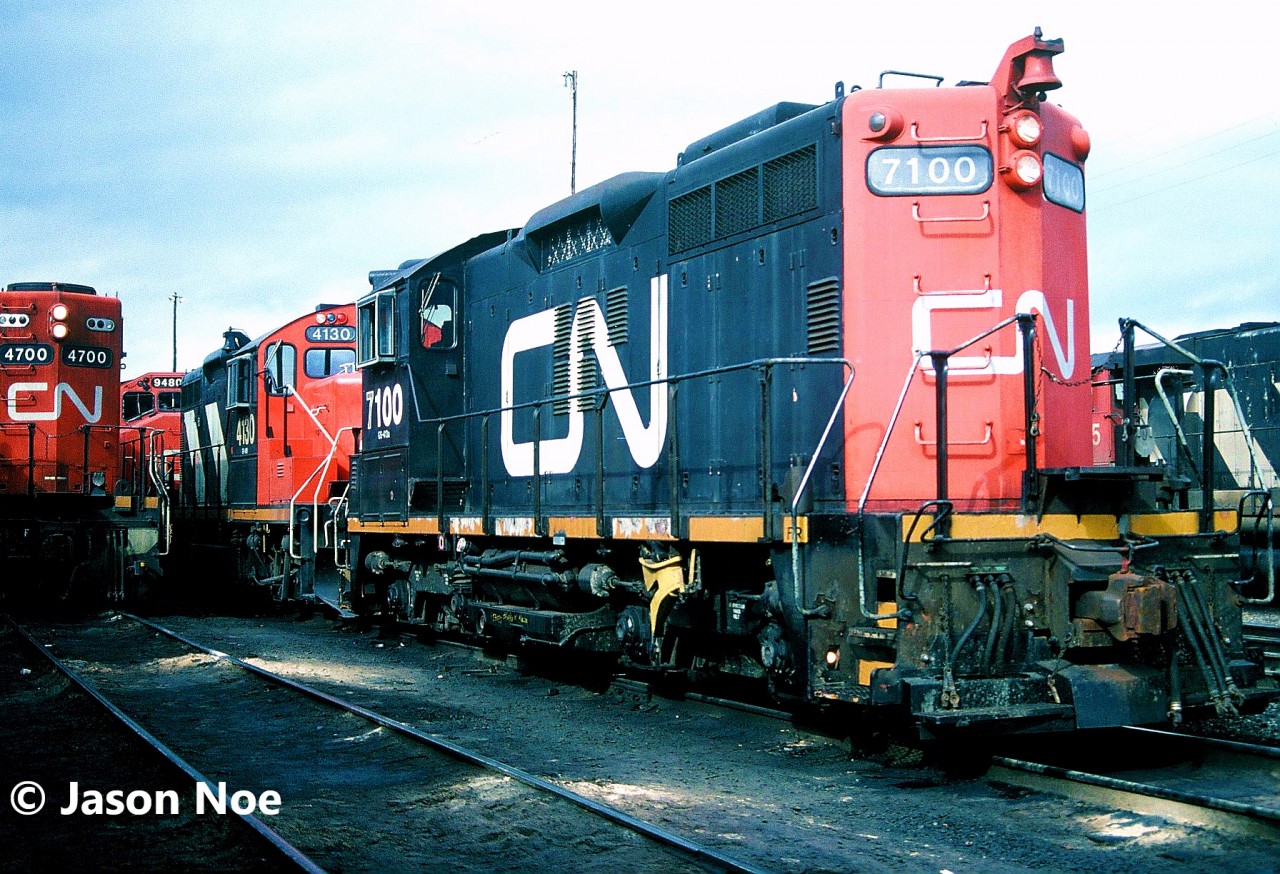 CN SW1200RSm 7100 and GP9RM 4130 are pictured waiting to depart the MacMillan Yard diesel shop tracks on an outbound train in Vaughn, Ontario.