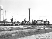 MLW units dominate the tracks around the diesel shop at Canadian Pacific's Agincourt (Toronto) Yard in east end Toronto. Visible from left to right are FB1 4409, RS10 8583, RS3 8430, RS10 8596 and RS18 8740. A lone GMD product is visible in the form of TH&B GP7 71, tucked away between CP units. A few tracks over, three other MLW units out of view appear to be load testing, or marking their territory against the London-built invader.
<br><br>
<i>Bill Grandin photo, Dan Dell'Unto collection slide.</i>

