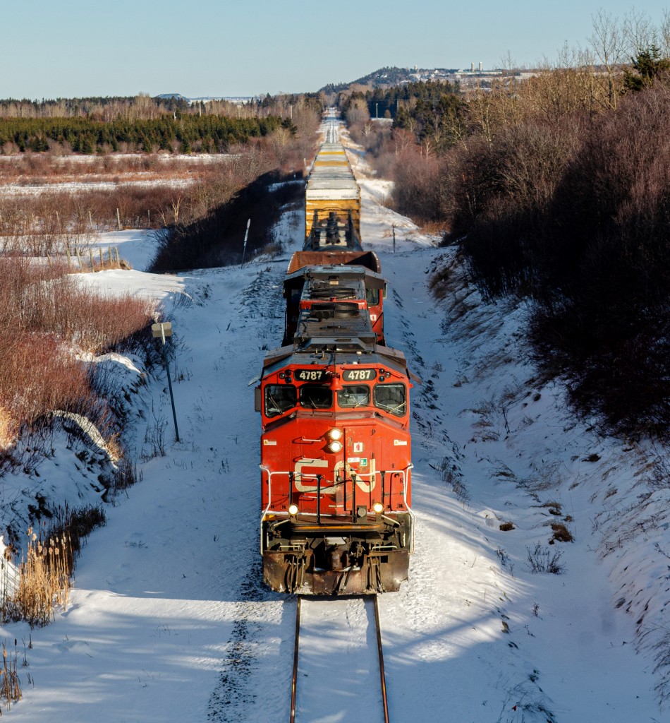 CN 4787 leading the Rivière-du-Loup turn as it is about to go under the Route 132 overpass, in Bic, on a sunny late morning. These days are nice to come by, as the last two months have been very cloudy!
The train had cars for all 4 customers currently served by this train, being 1 empty scrap gondola, for JM Bastille in Rivière-du-Loup, 2 tank cars for April Lubricants in L'Isle-Verte, about 10 boxcars for Cascades Packaging in Cabano (transloaded in Rivière-du-Loup), and at the very end of the train, 1 grain hopper for the Coop's grain elevator, just behind the camera.