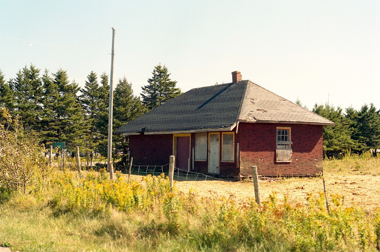 This is just an entry for the station junkies........and PEI fans.
The old Fredericton station began life in 1875 as a flag stop. But as the village grew; there was a need for a larger station with a good waiting room and large freight area. So, in 1904 a new station was built to serve the needs of the community. The new building was referred to as a 'Keeper' station; as it required someone there to keep an eye on it. As in "agent".
When I photographed this structure in 2001, it had been relocated a couple of hundred feet or so from its original location by the Confederation Trail which in turn was constructed on the old CN right of way. The station was sold in the early 1990s to a local and moved unto their farm property and the plans were to fix it up. But it never happened. By 2015 the old wooden structure was in derelict condition and part of the roof had caved in. I am under the opinion the building was razed. I could not find it in 2017.
Just another piece of history lost.  Shame.