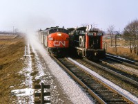 Just west of <a href=https://www.trha.ca/history/stations/pickering-station/>CN's Pickering station,</a> Toronto - Montreal train 14, the <i>Lakeshore,</i> flies past the Toronto - Oshawa wayfreight.

<br><br><i>Scan and editing by Jacob Patterson.</i>
