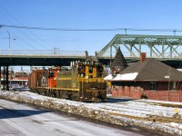 After meeting a Mimico - Toronto yard transfer <a href=https://www.railpictures.ca/?attachment_id=55943>about a mile north,</a> the Toronto - Mimico yard transfer passes Don station beneath Queen Street.  Note the yellow flag hung on the station wall.  As this train order semaphore was only equipped with green and red lenses, a yellow aspect had to be created to allow trains to grab orders on the fly.  Red signal with yellow flag by day, or lantern on the platform by night, permitted this operation.<br><br><i>Scan and editing by Jacob Patterson.</i>