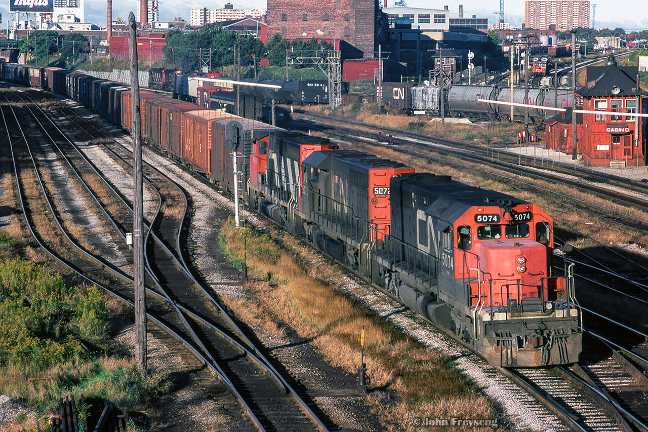 With passenger movements briefly in the clear, a handful of freight movements can get underway.  An eastbound freight behind CN 5074-5072-9424 approaches Bathurst Street, while a westbound swings around behind Cabin D, led by CN 3230-3201-4521-3120.  A van hop waits over on the Weston Sub to shove into TTR territory.

Scan and editing by Jacob Patterson.