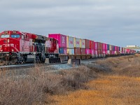 Two bright and shiny units bring their long line of intermodel cars into the West side of Winnipeg.