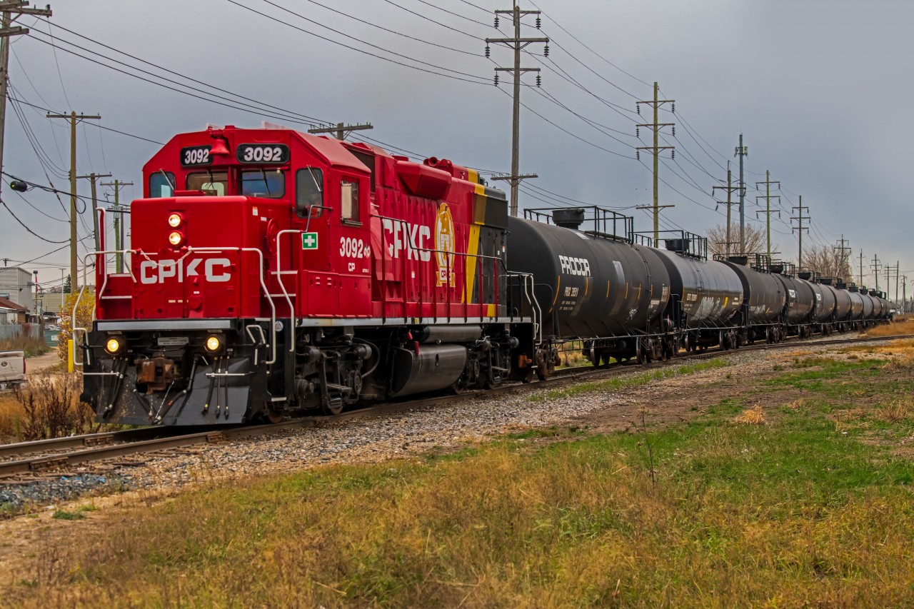 A freshly painted CPKC 3092 leading a line of tanker cars through the St. James neighborhood. On their way back into the CPKC Higgins yard.