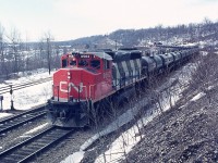 One of those days in which I was getting impatient for spring time, I guess. Was wandering up the old incline to the Canada Crushed Stone facility when I happened to notice an eastbound train in the distance. Oil train? In the distance the old Dunas station can be seen, along with the caboose on the rear. CN 9562 sole power. On the extreme right is the incline track I am walking along; and on the left is the track that ran off the main line down into Steetleys (Canada Crushed Stone) quarry operations. Operations ceased in the 1970s; track pulled up and the area below the tracks in now a housing development.